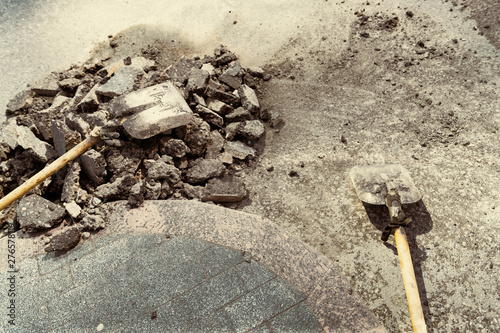 Two shovels next to pieces of old asphalt pavement, road repair work.