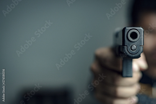 Obraz na plátně Man is shooting a gun , selective focus on front gun,use for add text