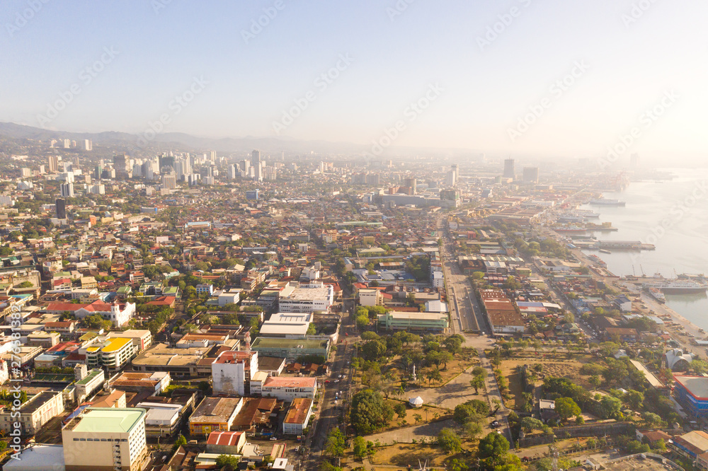Cityscape in the morning. Streets and seaport of the city of Cebu, Philippines, top view. Panorama of the city with houses and business centers.