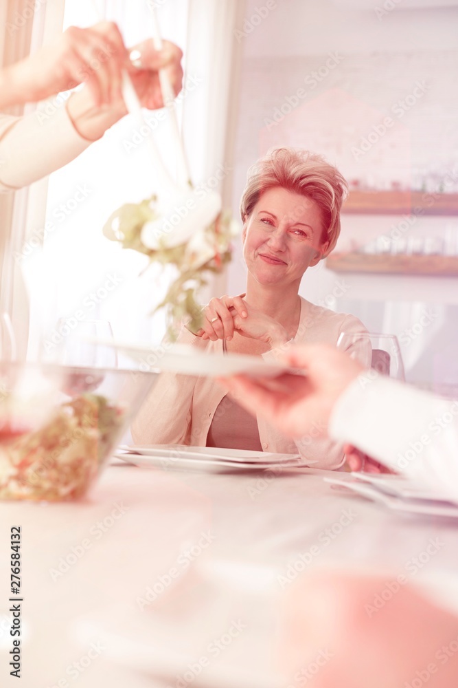 Smiling woman looking at friend serving salad to man Smiling woman looking at friend serving salad to man