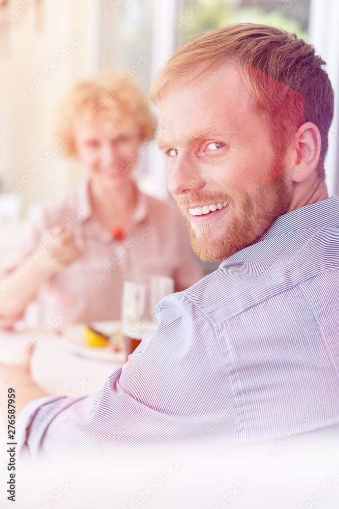 Portrait of smiling man sitting with woman in restaurant Portrait of smiling man sitting with woman in restaurant