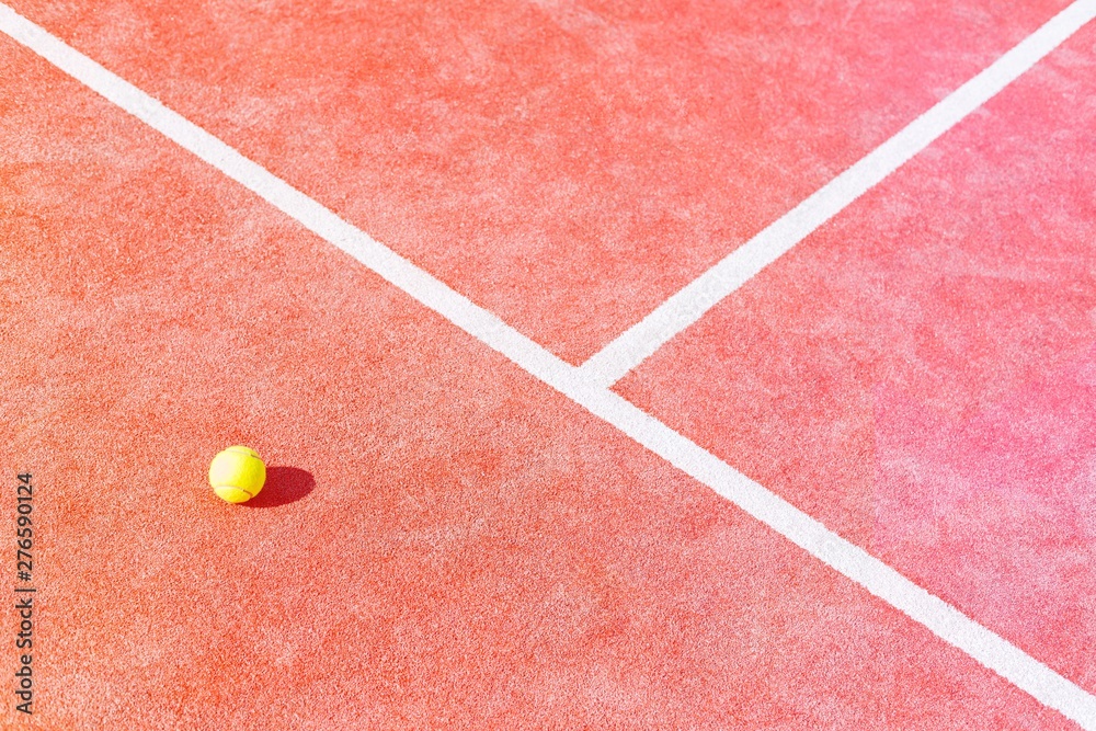 High angle view of tennis ball on red court during sunny day