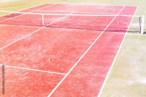 High angle view of empty red tennis court on sunny day