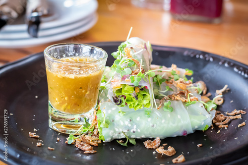 Fresh organic vegetable Thai Fresh spring rolls with sauce in restaurant on wooden background close up. Healthy food.