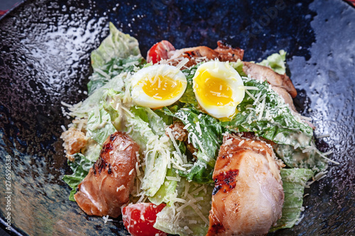 Closeup view on fresh salad with egg and meat bowl. Selective focus Flat lay food for lucnh with copy space. Picture for menu. Modern Caesar salad photo