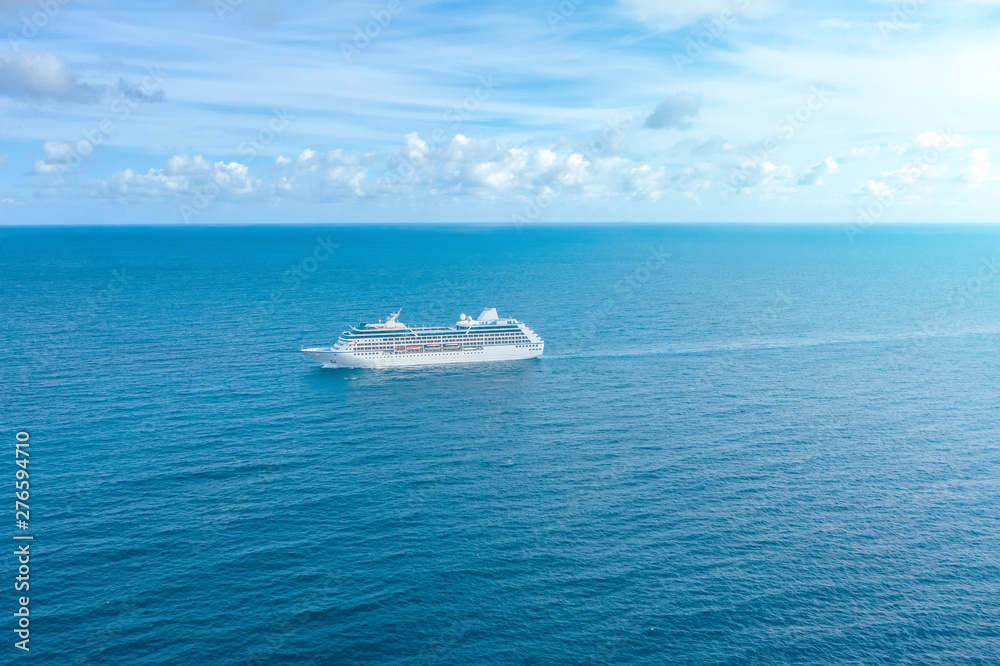 Cruise ship liner sails in the blue sea leaving a plume, seascape. Aerial view The concept of sea travel, cruises.