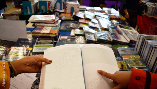 2 people are reading a book in Book Fair