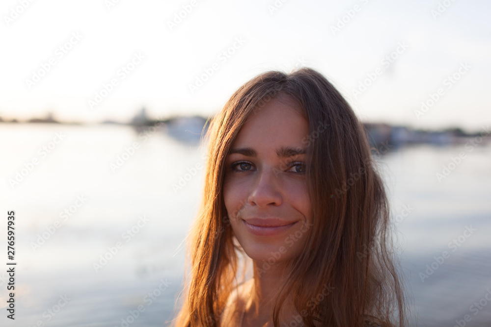 Closeup portrait of effective girl with long hair smiling to camera having fun on the beach,vacation mood