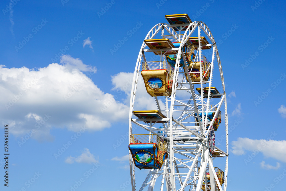 colorful carousel wheel against a blue sky