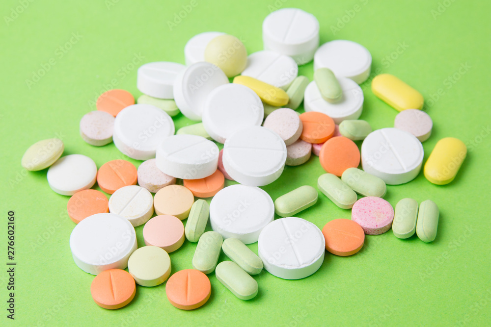 Medicines pills, drugs and antibiotics on a green background. Medicine and health care. Medicines pills, drugs and antibiotics on a green background. Medicine and health care.