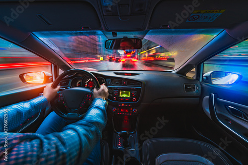 Fototapeta Naklejka Na Ścianę i Meble -  A man is driving along the highway. Evening time during the rain.