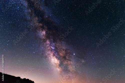 Beautiful night landscape. Starry night and bright milky way galaxy over the hills.