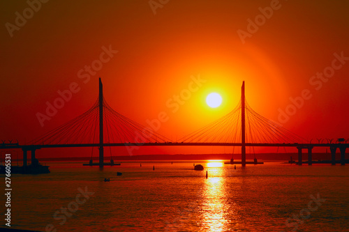 cable bridge silhouette against the setting sun © Sergey
