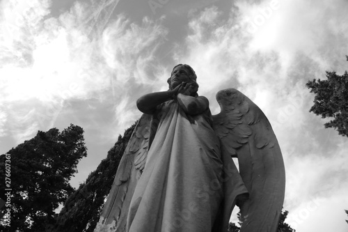 Escultura de ángel con manos en la cara. Drama en blanco y negro