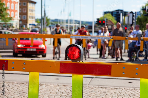 Jönköping, Sweden - Jun 22, 2019: Red light at train bars, people waiting to cross