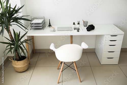 office table on which laptop, coffee, tablet, camera and other items