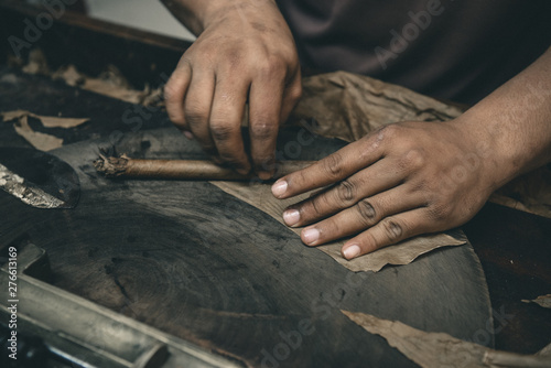 Closeup of hands making cigar from tobacco leaves. Traditional manufacture of cigars. Dominican Republic