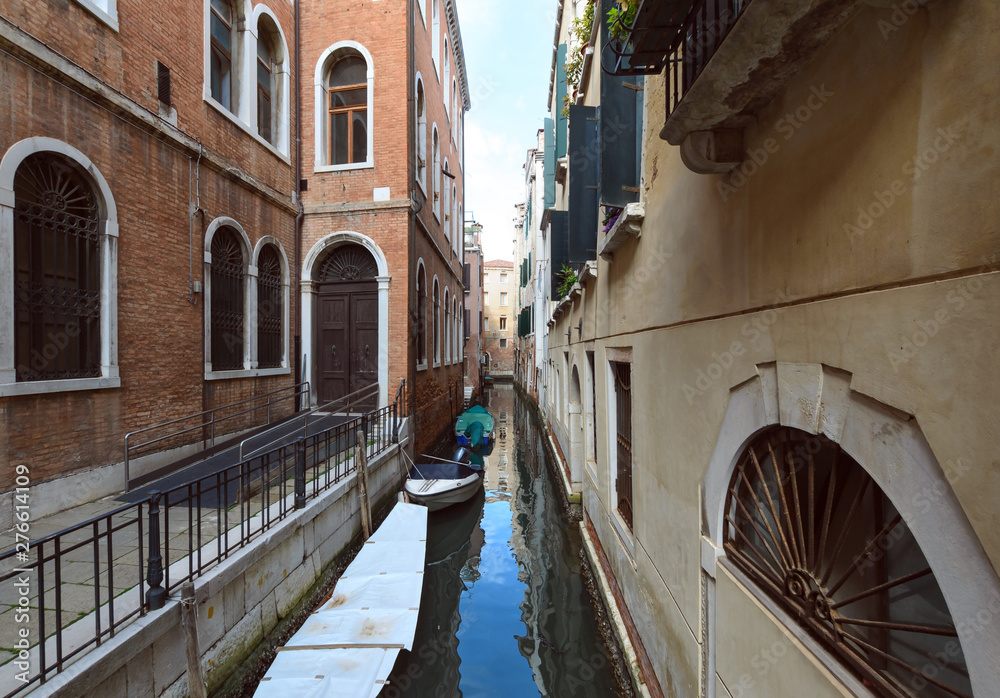 Canal with covered boats in Venice