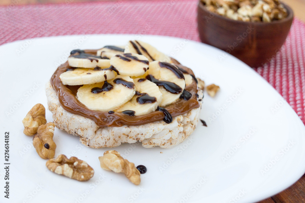 Rice biscuit with dulce de leche and pieces of banana and nuts. Accompanied with a milk banana smoothie. Added low calorie chocolate. Rice biscuit with dulce de leche and pieces of banana and nuts. Accompanied with a milk banana smoothie. Added low calorie chocolate.