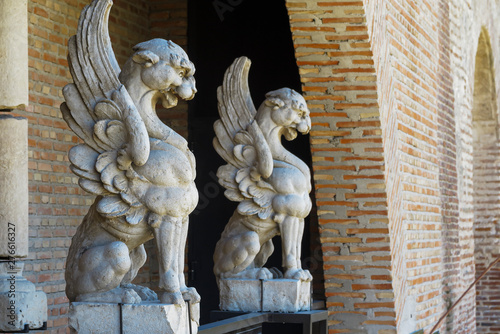 horizontal side view of two gargoyles carved in stone