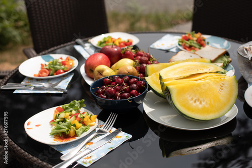 Delicious food from garden served on the table in backyard or terrace. Summer picnic concept. Salad served on the plates.