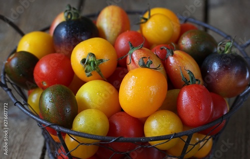 cherry tomatoes are different varieties in the basket  small tomatoes of different colors and types.