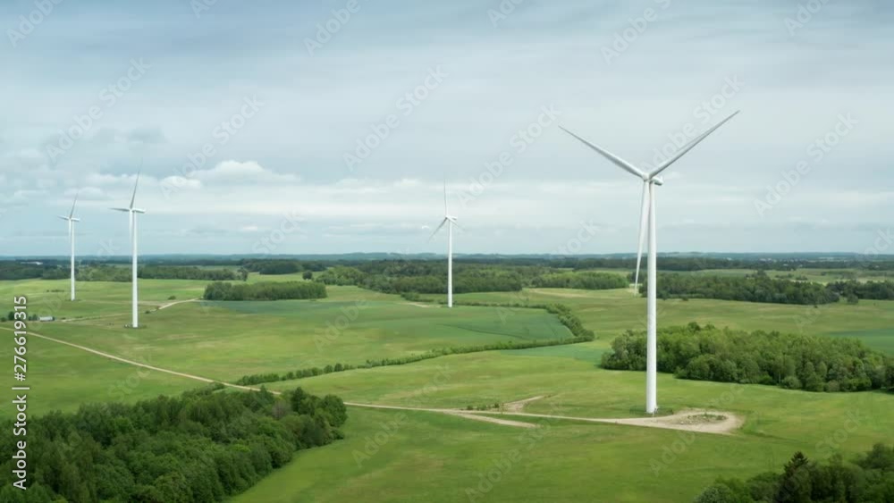 Drone shot of wind power turbines on background of green coutryside landscape. Aerial footage of wind generators on energy station, alternative source of renewable energy, environment friendly concept Drone shot of wind power turbines on background of green coutryside landscape. Aerial footage of wind generators on energy station, alternative source of renewable energy, environment friendly concept