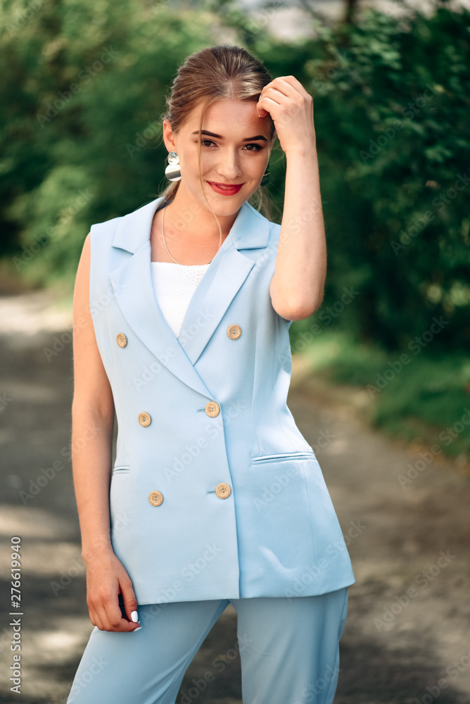 Gorgeous young model woman with perfect hair looking at camera posing in the city wearing classic costume. Gorgeous young model woman with perfect hair looking at camera posing in the city wearing classic costume.