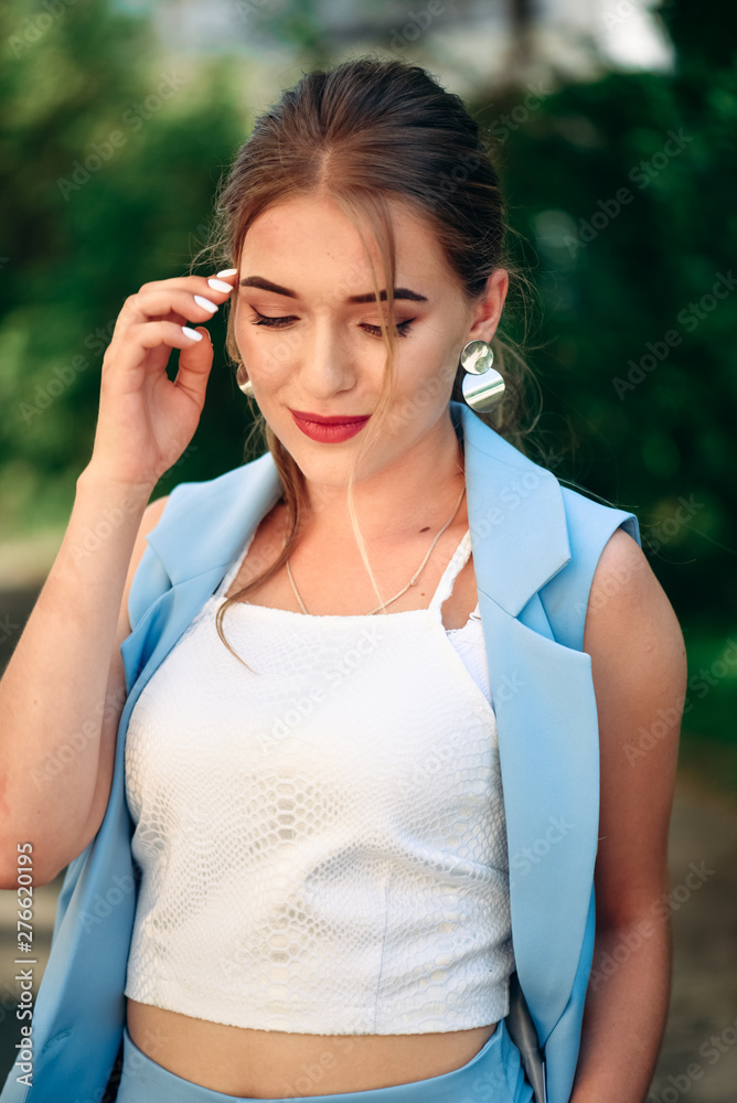 Gorgeous young model woman with perfect hair looking at camera posing in the city wearing classic costume. Gorgeous young model woman with perfect hair looking at camera posing in the city wearing classic costume.