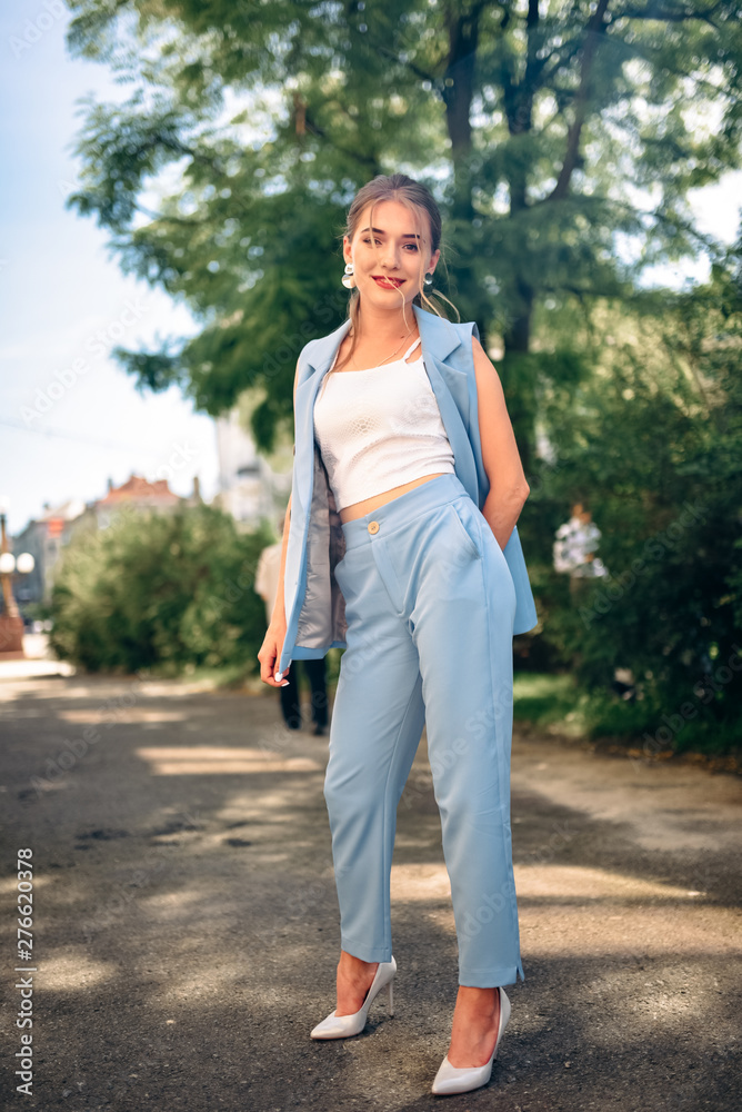 Gorgeous young model woman with perfect  hair looking at camera posing in the city wearing  classic costume.