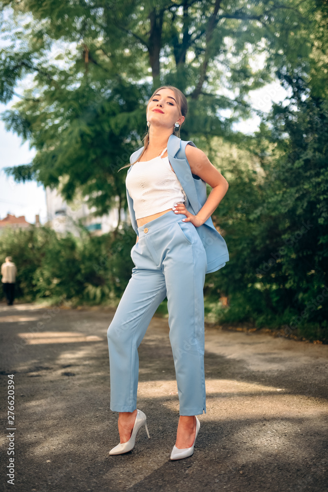 Gorgeous young model woman with perfect hair looking at camera posing in the city wearing classic costume. Gorgeous young model woman with perfect hair looking at camera posing in the city wearing classic costume.