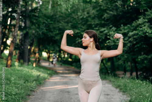 Stylish girl in a sportwear. Cute woman standing in a sunny park.