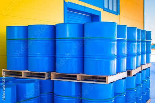 Blue containers loaded on pallets. Plastic barrels for toxic products. Chemical storage tanks. Barrels for shipment from stock. Transport of hazardous substances. Warehouse work. Logistics in stock.