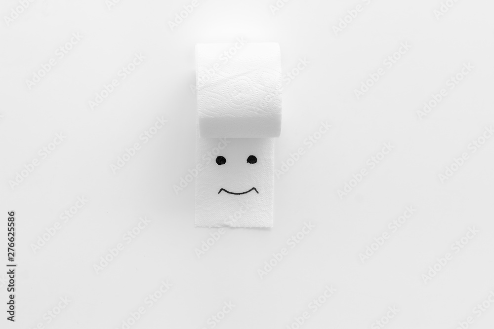 Toilet paper roll with painted face for proctology diseases concept on white background top view Toilet paper roll with painted face for proctology diseases concept on white background top view