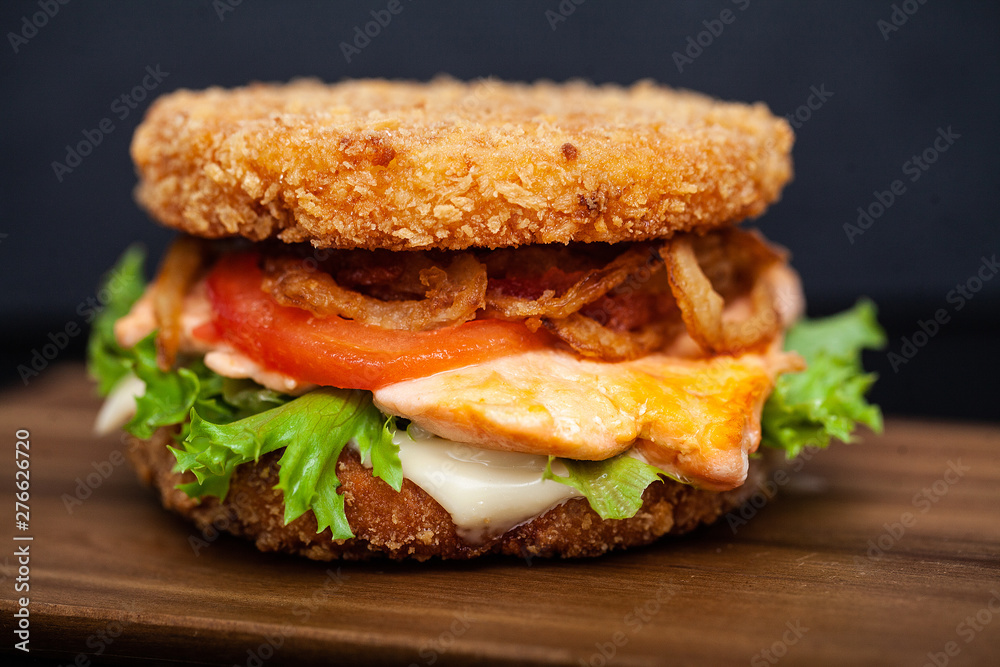 Sushi Burger with a variety of tasty ingredients on a dark background Sushi Burger with a variety of tasty ingredients on a dark background