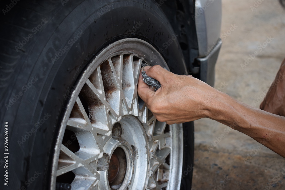 Men are washing old tires, dirty cars with bare hands. Men are washing old tires, dirty cars with bare hands.