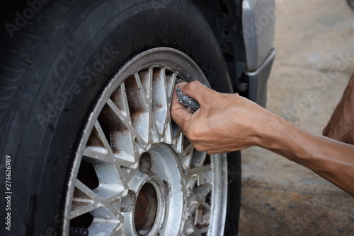 Men are washing old tires, dirty cars with bare hands.