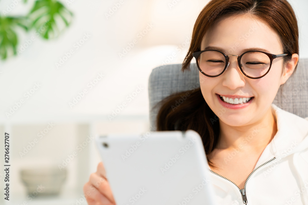 部屋でタブレットを見る女性 部屋でタブレットを見る女性