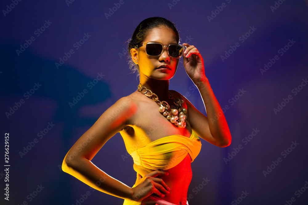 Fashion Asian Woman Tan skin black hair beautiful high fashion make up  sunglasses pearl necklace accessories wear yellow bikini. Studio Lighting  Dark smoke Background copy space text logo Stock Photo | Adobe
