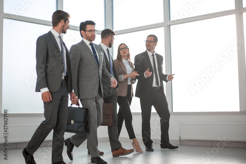 Businesspeople walking in the office background. © ASDF