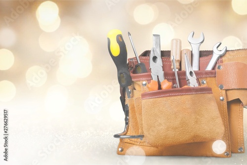 Tool belt with tools on wooden background photo