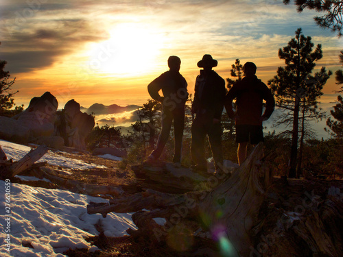 Hikers Silhouetted on Snowy Peak Sunset