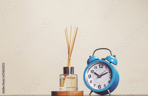 bottle of fragrance diffuser with sticks and a vintage clock isolated . air freshener . Relaxation time . art of living concept