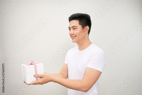 A happy handsome man presenting some gifts. Isolated on white background. © makistock