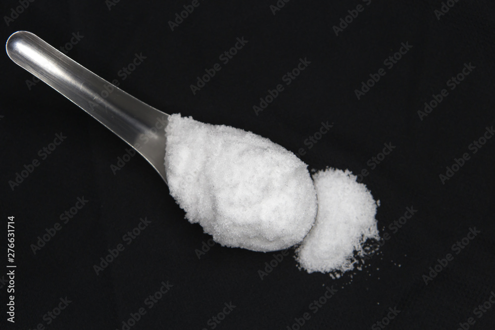 Sea salt in spoon on black background Sea salt in spoon on black background