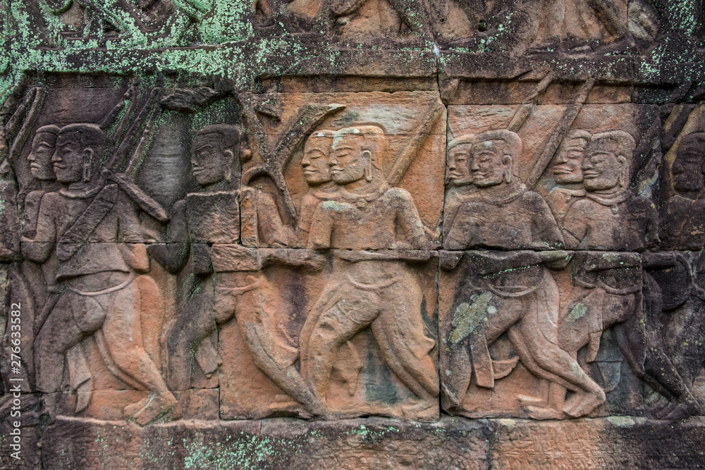A series of bas-reliefs tells the historical events and everyday life of ancient Khmer people at the outer gallery of Bayon temple, Cambodia. 