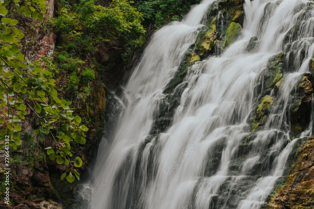  waterfall in the mountains. green stones