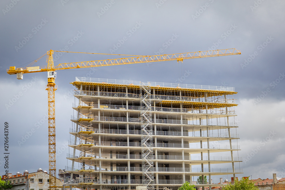 The construction of a modern business center. Yellow crane on the construction of a new building.