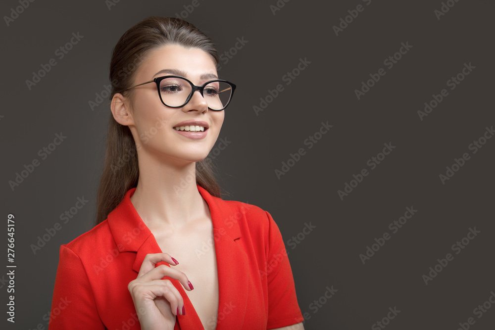 Portrait of a stylish business woman with glasses. Pretty smile. Dark background Portrait of a stylish business woman with glasses. Pretty smile. Dark background