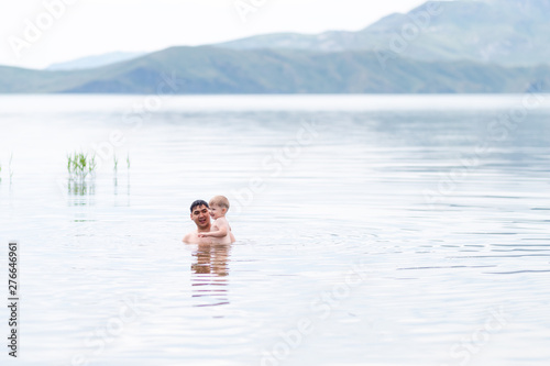 father with little son swimmind in sea, beautiful landscape sea and mountines © Anastassiya 